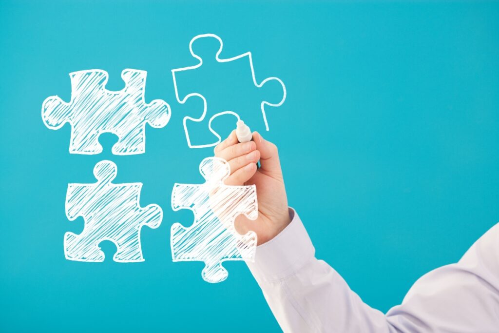 main traçant des pièces de puzzle symbolisant la compréhension de l'autisme